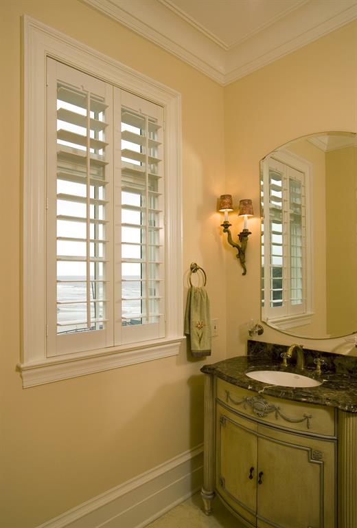White shutters in a bathroom looking out over ocean